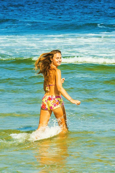 Glückliche junge Frau watet auf dem Wasser. — Stockfoto