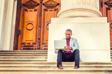 Genç Afro-Amerikan dışında dizüstü bilgisayarda çalışan adam