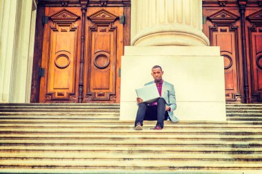 Genç Afro-Amerikan dışında dizüstü bilgisayarda çalışan adam