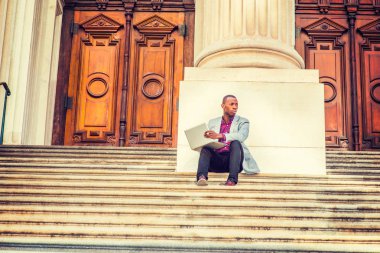 Genç Afro-Amerikan dışında dizüstü bilgisayarda çalışan adam