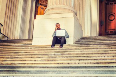 Genç Afro-Amerikan dışında dizüstü bilgisayarda çalışan adam