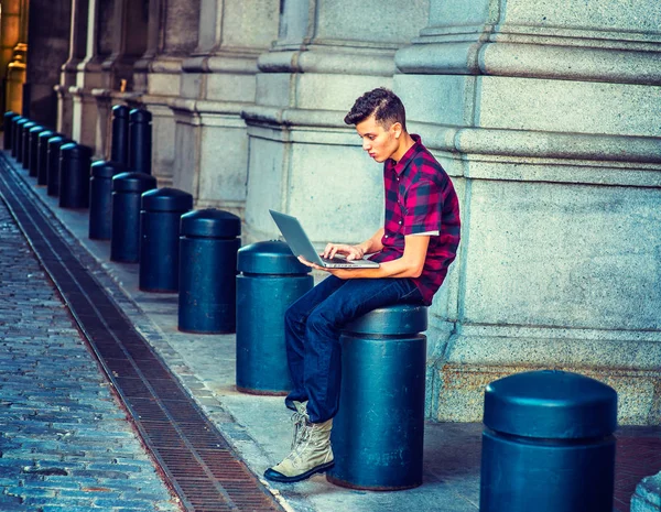 Молодой американец работает за компьютером на улице в Нью-Йорке — стоковое фото