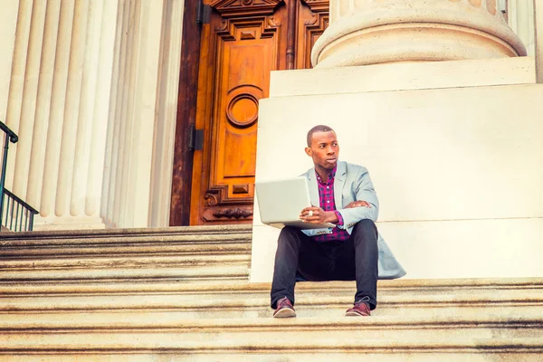 Joven hombre afroamericano que trabaja en el ordenador portátil fuera en — Foto de Stock