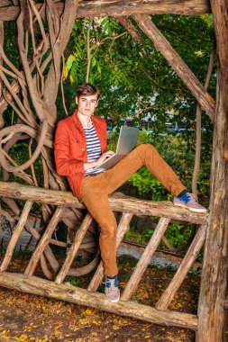 Genç dizüstü bilgisayarda çalışarak, Central Park'ta rahatlatıcı adam, 