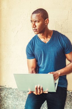 dizüstü bilgisayar üzerinde çalışan genç adam