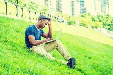 Genç Afro-Amerikan açık içinde dizüstü bilgisayarda çalışan adam