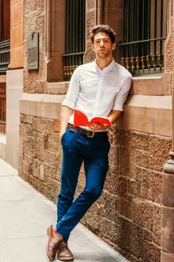 Genç Amerikalı adam New York'ta dışında kırmızı kitap okuma