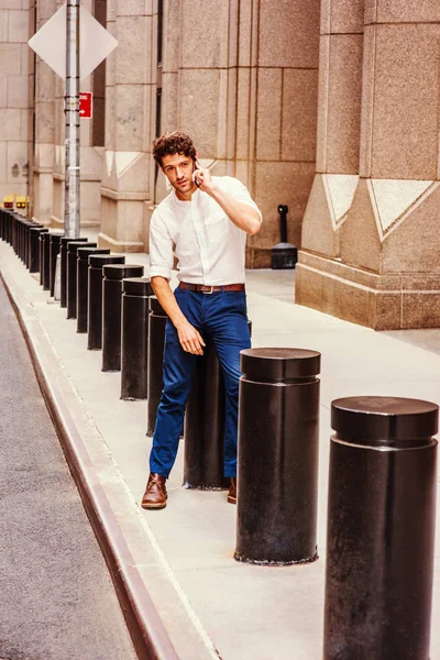 Genç yakışıklı Amerikalı adam'yeni dışında cep telefonuyla konuşuyor