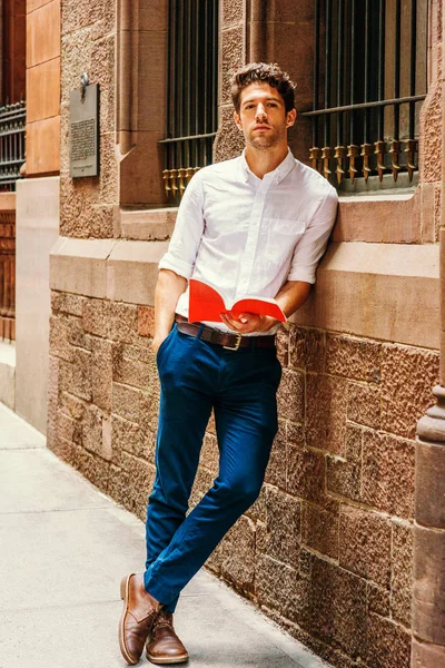 Genç Amerikalı adam New York'ta dışında kırmızı kitap okuma
