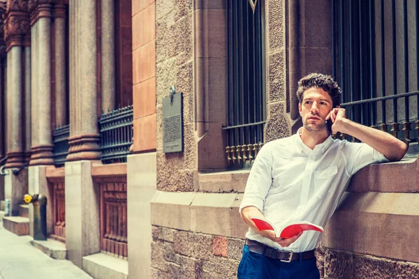 Yeni Yor içinde dışında cep telefonuyla konuşan kitap okumak, genç adam