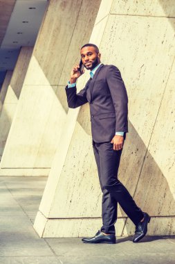 Genç işadamı New York dışında cep telefonuyla konuşuyor