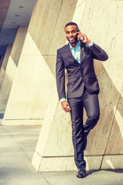 Genç işadamı New York dışında cep telefonuyla konuşuyor