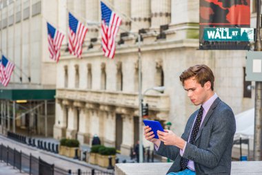 Genç adam Wall Street New York'ta tablet bilgisayarda okuma