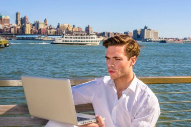 Genç nehir tarafından dizüstü bilgisayarda çalışan adam