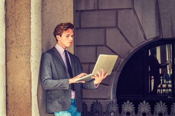 Genç işadamı dışında dizüstü bilgisayar üzerinde çalışan