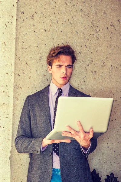 Genç işadamı dışında dizüstü bilgisayar üzerinde çalışan