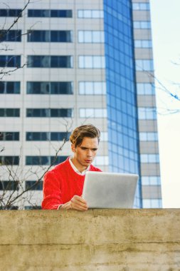 Genç adam dizüstü bilgisayarda uzaktan çalışma.