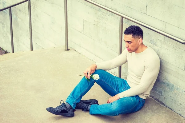 Young handsome American Man holding white rose, thinking outside — Stock Photo, Image