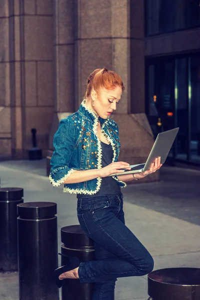Young Businesswoman working on computer outside in New York