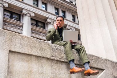 Amerikan seyahat, New York'ta çalışma, yeşil elbise, kahverengi deri ayakkabılar, dizüstü bilgisayar, cep telefonu arama çalışma vintage binalar, sokakta siting işadamı