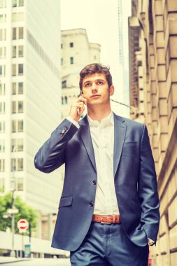 Modern günlük yaşam. Genç yakışıklı adam New York 'ta seyahat ediyor, mavi takım elbiseli, beyaz gömlekli, el ele, yüksek binalarla sokakta yürüyor, cep telefonuyla konuşuyor, bakıyor, düşünüyor.