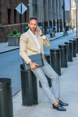 Avrupa seyahat, New York City'de küçük gri saç, sakal, çalışma işadamı bej ceket giyen gri pantolon, deri ayakkabı, sokakta oturan, cep telefonuyla konuşurken holding evrak çantası