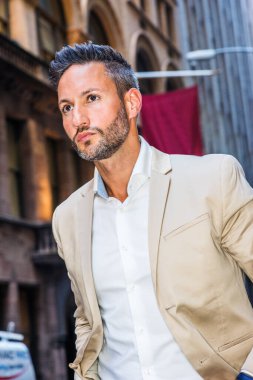 New York 'ta gezen sakallı yakışıklı Avrupalı genç bir adam. Genç adam bej rengi alevler içinde, beyaz gömlekli, dar bir klasik sokakta pankartlarla yürüyor, ileriye bakıyor, ciddi ciddi düşünüyor..