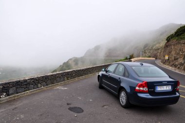 Tenerife, İspanya - 6 Temmuz 2011: dağda bulutların arasındaki yol park edilmiş araba duruyor..