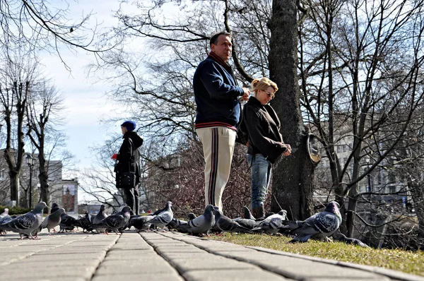 RIGA, LETTONIE - 13 AVRIL 2011 : Dans les premiers jours chauds du parc de printemps de la ville, des inconnus nourrissaient les oiseaux . — Photo