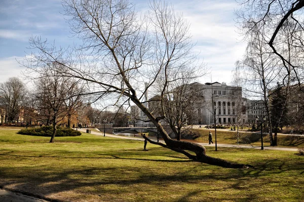 Riga, Lettland - April 13, 2011: Park och operahus under de första dagarna på våren efter snösmältningen. — Stockfoto