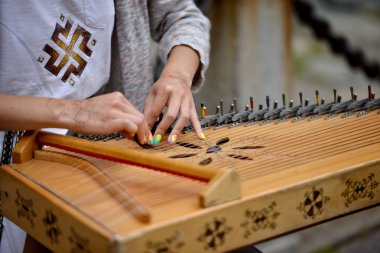 Riga, Letonya - 27 Temmuz 2016: Bilinmeyen kız sokakta geleneksel kostümlü bir harp çalış.