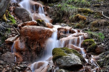 Demir çelik kirleri büyük taşların üzerinde akan kaynaklarıyla.