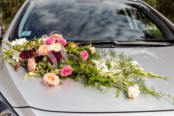 Flower decoration on gray wedding car bonnet. Stock Photo