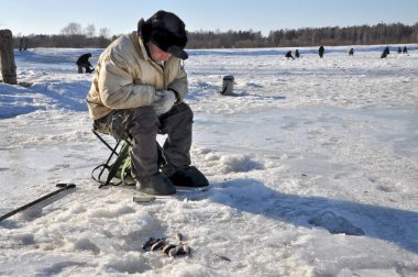 Bilinmeyen buz fener donmuş nehrin üzerinde balık yakalamak.
