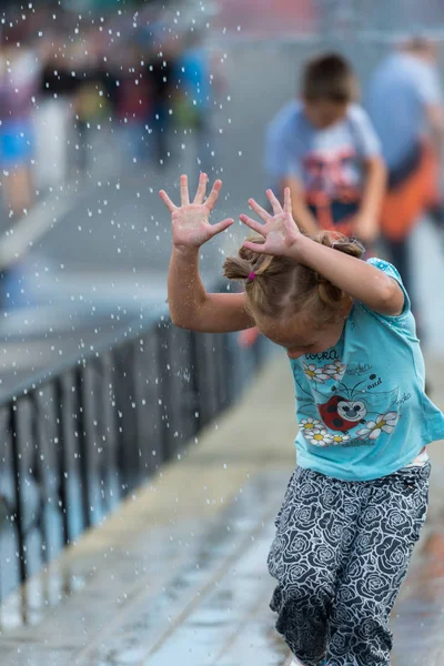 Lidé na ulicích Rigy Festival City. Děti jsou šťastné s vodními atrakcemi. — Stock fotografie