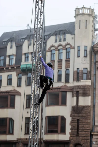 RIGA, Letonia, 9 de septiembre de 2014: El trabajador sube a un andamio —  Fotos de Stock