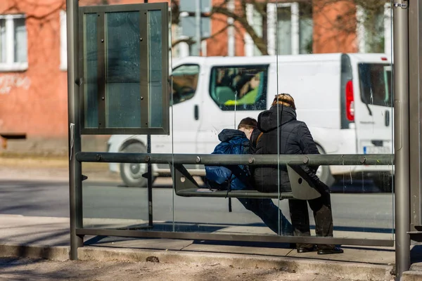 Menschen, die an der Bushaltestelle auf den Bus warten. Blick von hinten. — Stockfoto