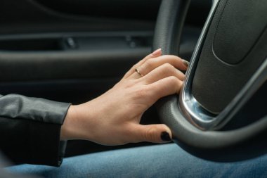 Kadınların elleri otomobilin direksiyon simidi üzerinde.