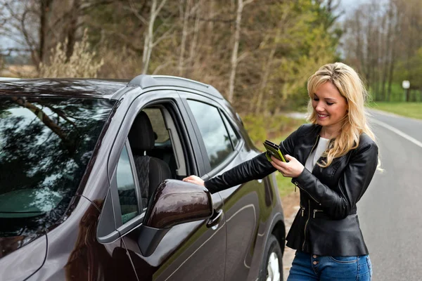 Junge attraktive verzweifelte und verwirrte Frau, die neben ihrem Auto steht und mit dem Handy spricht — Stockfoto