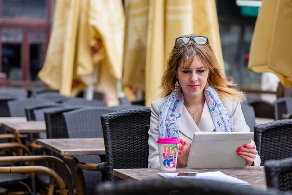 一个年轻的企业妇女喝茶在咖啡馆和工作 — 图库照片