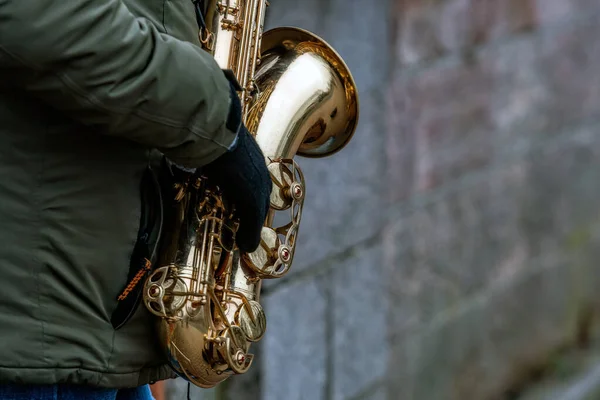 Primo piano di un sassofono nelle mani di un musicista di strada — Foto Stock