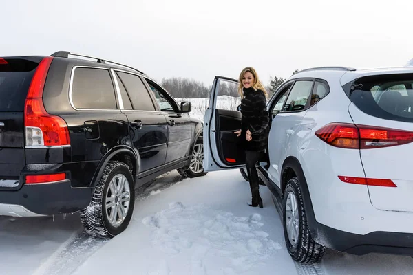 La mujer rubia sale del coche suv blanco y mira hacia atrás . — Foto de Stock