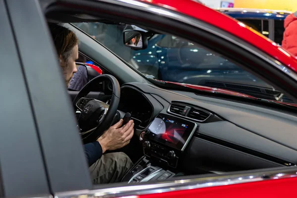 Riga, Latvia - 12. april 2019: En mann i et bilverksted ser på og tester en ny bil – stockfoto