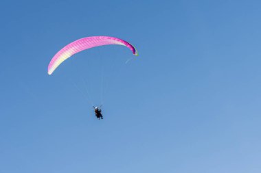 Cenevre, İsviçre - 14 Nisan 2019: Açık mavi gökyüzüne karşı İsviçre Alplerinde paragliding