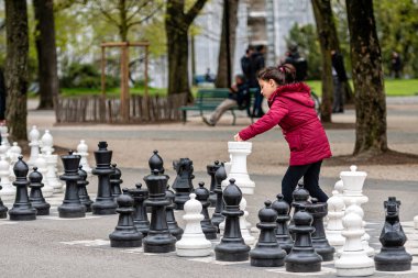 Cenevre, İsviçre - 16 Nisan 2019: Parc des Bastions 'da insanlar geleneksel büyük boy sokak satrancı oynuyorlar