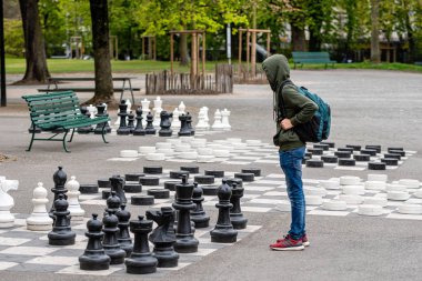 Cenevre, İsviçre - 16 Nisan 2019: Parc des Bastions 'da insanlar geleneksel büyük boy sokak satrancı oynuyorlar