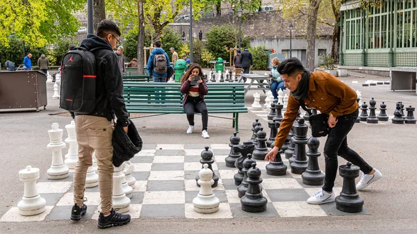 제네바, 스위스 - 2019 년 4 월 16 일 : PARC Des bastions 에서 전통적으로 규모가 큰 길거리 체스를 하는 사람들 — 스톡 사진