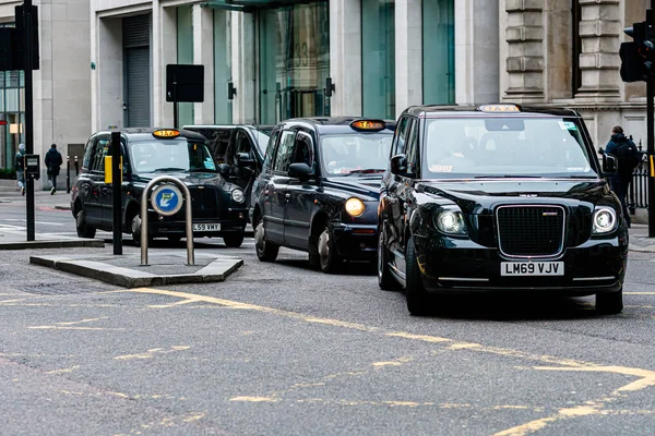 London, England, UK - December 31, 2019:   Typical black London cab in city streets. Traditionally Taxi cabs are all black in London but now produced in various colors — Stock Photo, Image