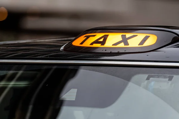 Een Brits London zwarte taxi bordje met onscherpe achtergrond — Stockfoto