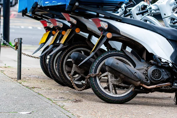 The rear wheels of the pizza delivery scooter chain are locked with an anti-theft chain — 스톡 사진